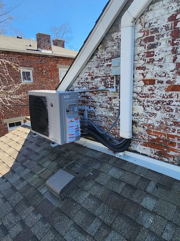 Ductless mini-split outdoor unit roof-mounted at a historic brick building